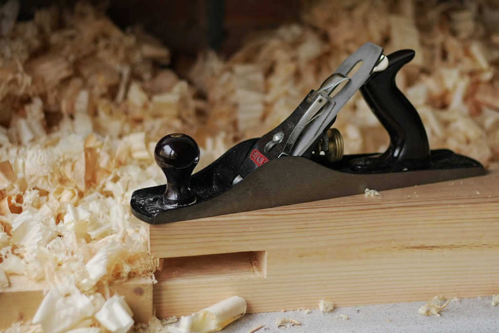 Well-used hand tools arranged on a home workbench